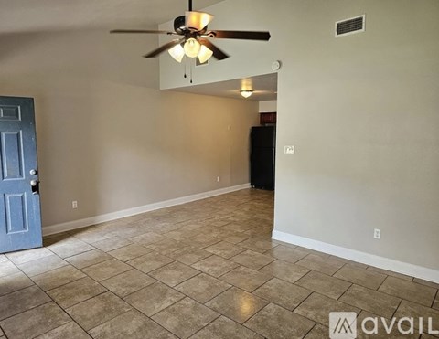 A room with a ceiling fan and tile flooring.