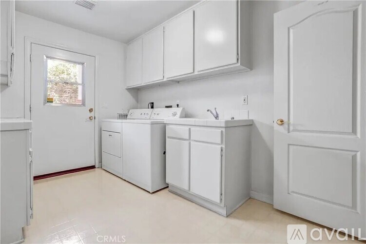 A white kitchen with a window and a sink.