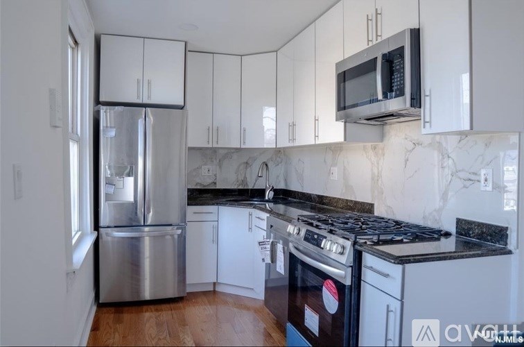 A kitchen with a stainless steel refrigerator, oven, and cabinets.