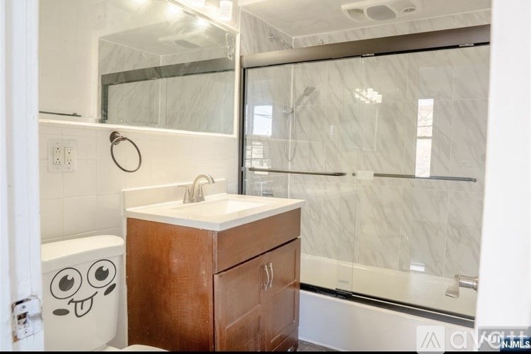 A bathroom with a toilet, sink, and a glass shower door.