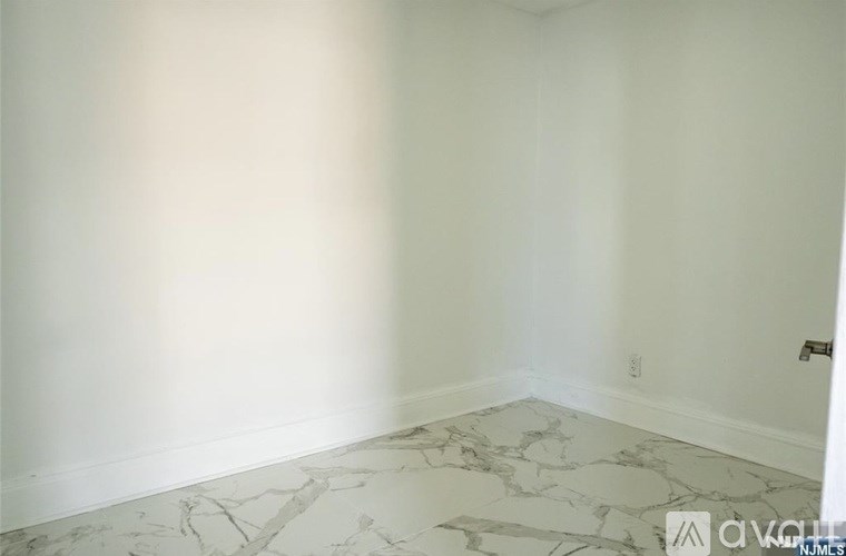 A room with a marble floor and white walls.