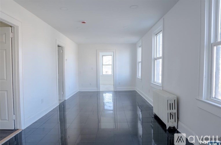 A spacious room with a black floor and white walls.