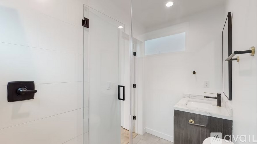 A modern bathroom with a walk-in shower and a sink vanity.