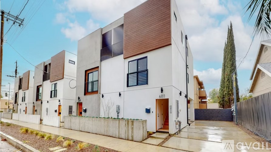 A modern two-story building with a white exterior and brown accents.