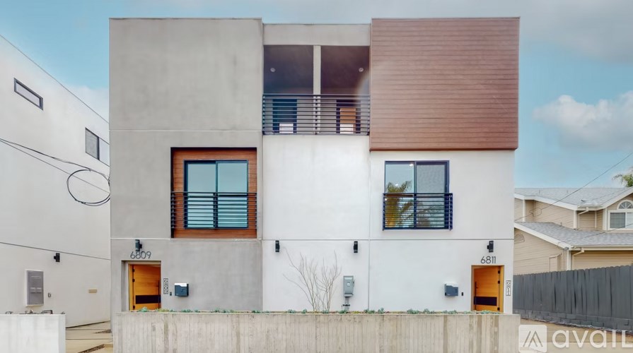 A modern house with a white exterior and a brown roof.