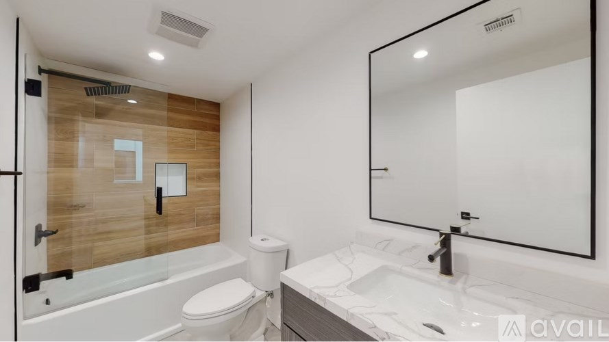 A modern bathroom with a wooden wall panel and a white toilet.
