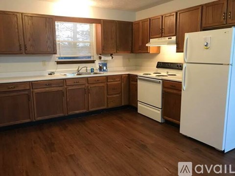 A kitchen with wooden cabinets and a white refrigerator.