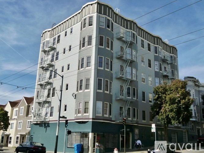 A tall building with a grey facade and a fire escape on the side.