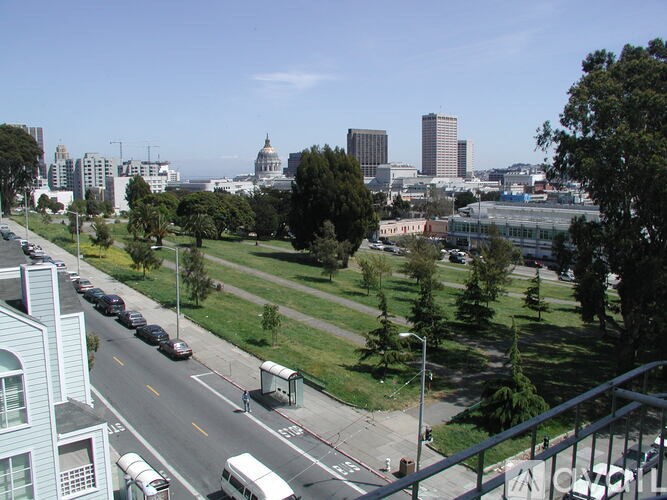 A city street with cars and a bus on a sunny day.