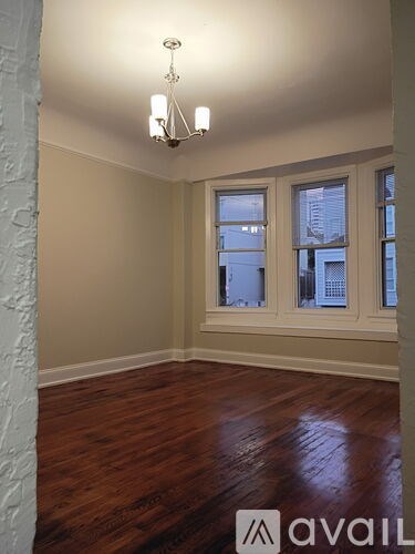 A room with wooden floors and a chandelier.