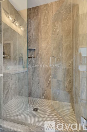 A shower area with a glass door and a tiled floor.