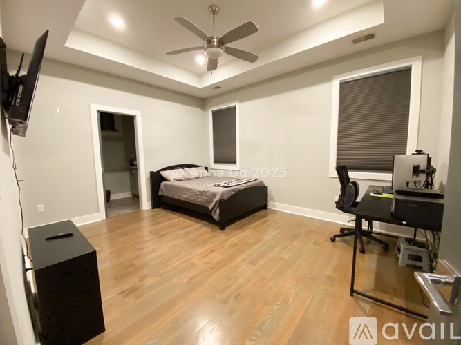 A bedroom with a bed, desk, and chair.