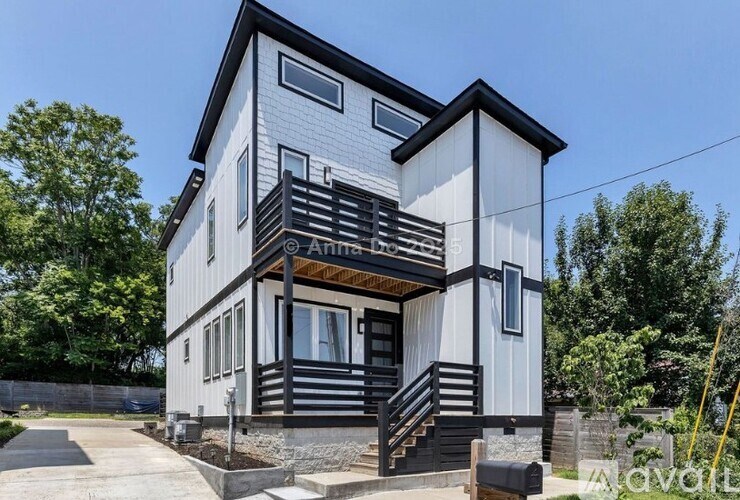 A modern two-story house with a balcony on the upper floor.