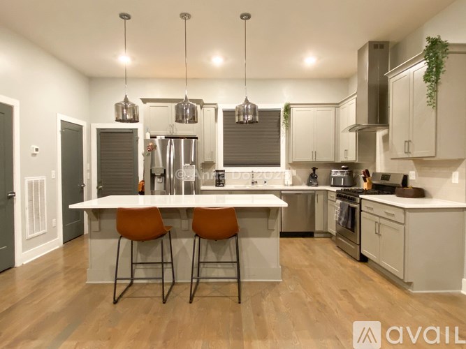 A modern kitchen with a center island and pendant lights.