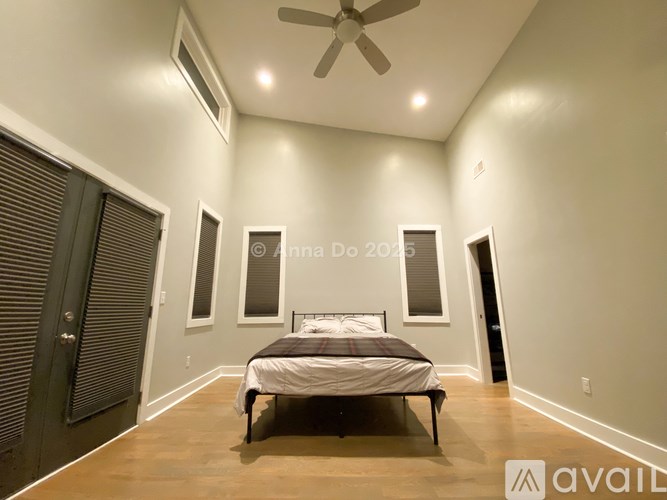 A bedroom with a bed, a ceiling fan, and a window with blinds.