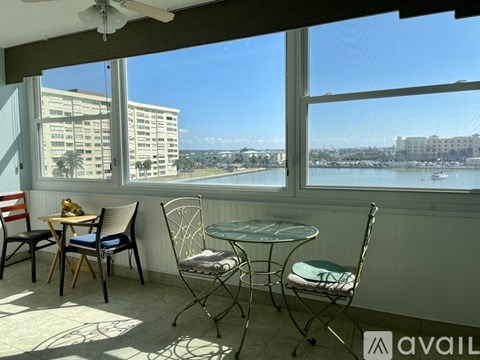 A balcony with a table and chairs overlooking a body of water.