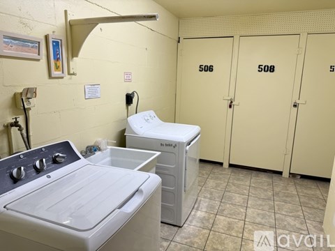 A laundry room with washer and dryer units and lockers numbered 506, 508, and 500.