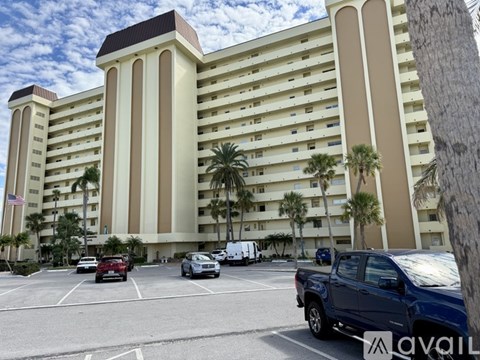 A large beige building with palm trees in front of it.