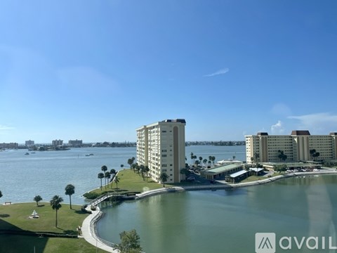 A view of a waterfront with buildings and palm trees.