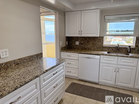 A kitchen with granite countertops and white cabinets.