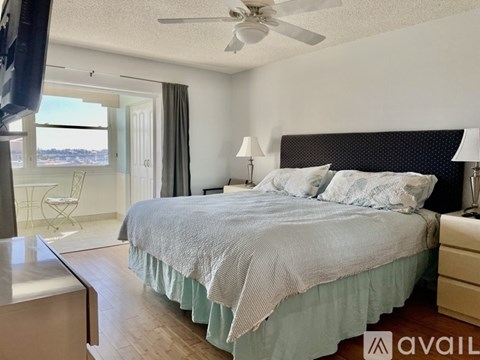 A bedroom with a bed, nightstand, and chair.