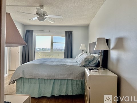 A bedroom with a bed, nightstand, and a ceiling fan.