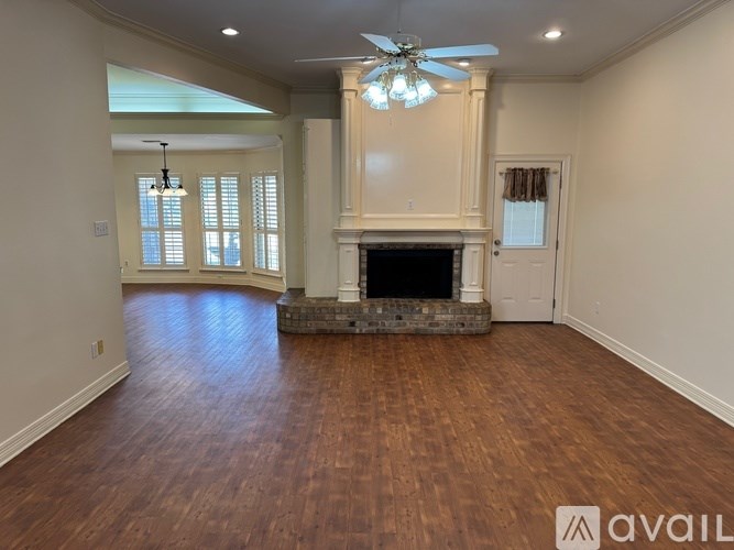 A spacious room with a fireplace and a ceiling fan.