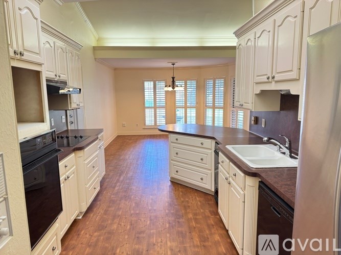 A kitchen with wooden floors and white cabinets.