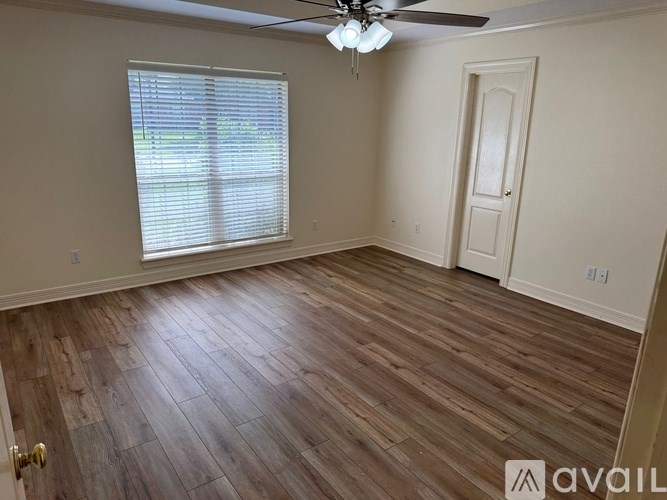 A room with wooden flooring and a ceiling fan.