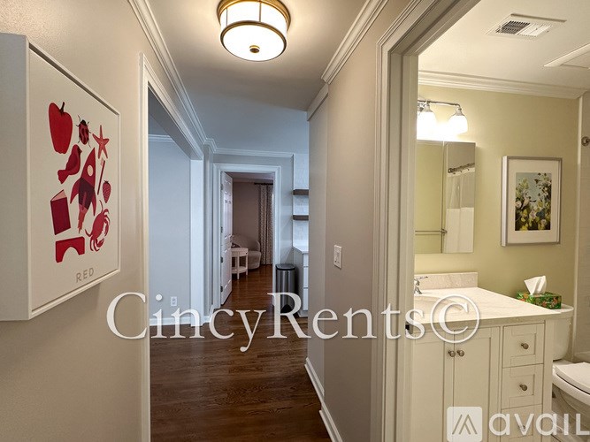 A hallway with a white cabinet and a framed picture of apples on the wall.