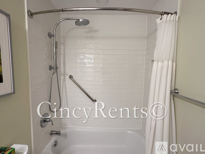 A white bathtub with a shower head and curtain.
