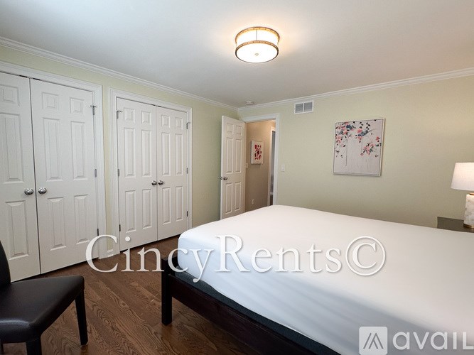 A bedroom with a bed, chair, and wardrobe.