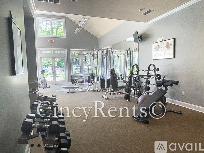 A gym with a variety of equipment including dumbbells, weight machines, and a bench press.