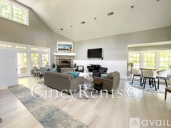A living room with a fireplace and a television on the wall.