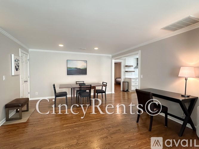 A well-lit room with a dining table and chairs.