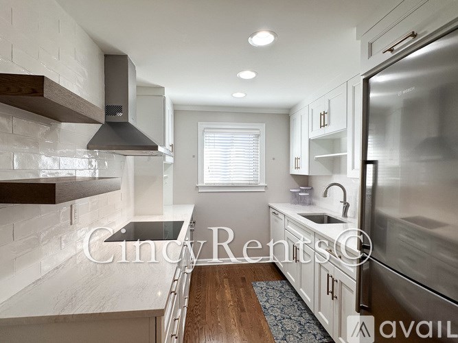 A modern kitchen with stainless steel appliances and white cabinetry.