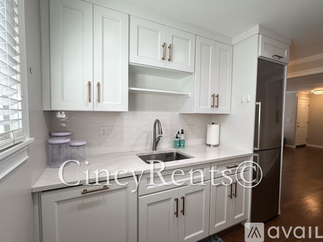 A kitchen with white cabinets and a sink.