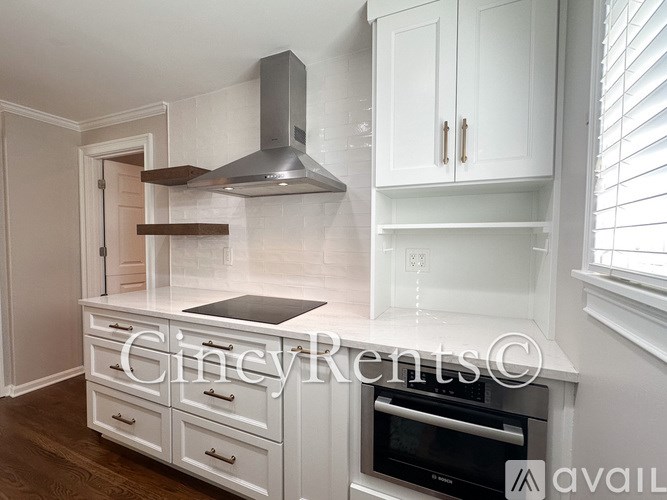 A kitchen with white cabinets and a stainless steel range hood.