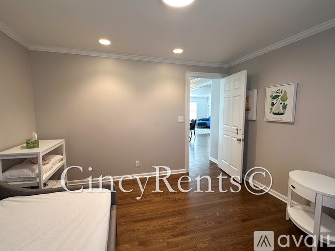 A bedroom with a bed, a nightstand, and a small table with a lamp on it.
