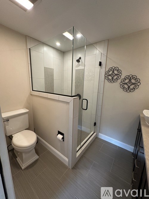 A bathroom with a toilet, sink, and shower.