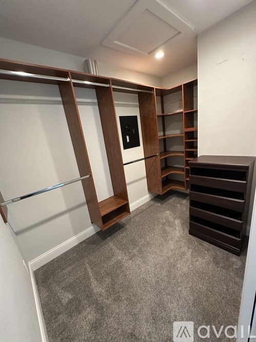 A room with a grey carpet and a white wall with a sliding door.