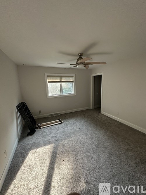 A room with a ceiling fan and a window.