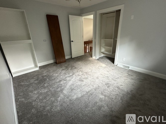 A room with a grey carpet and white walls.
