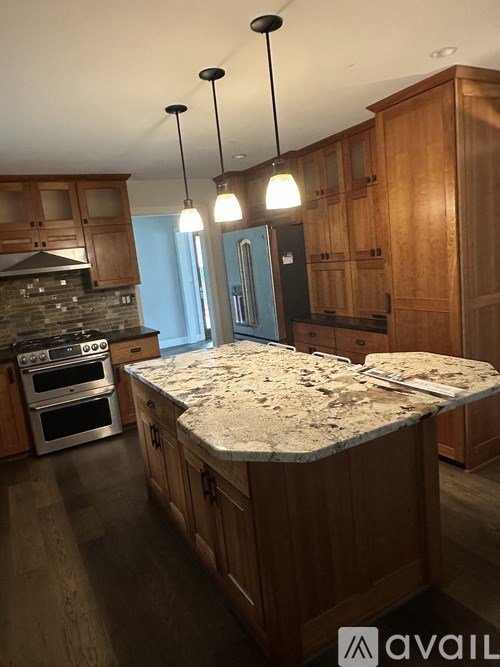 A kitchen with wooden cabinets and a granite countertop.