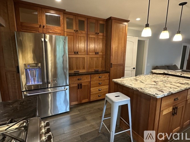 A kitchen with wooden cabinets and a stainless steel refrigerator.