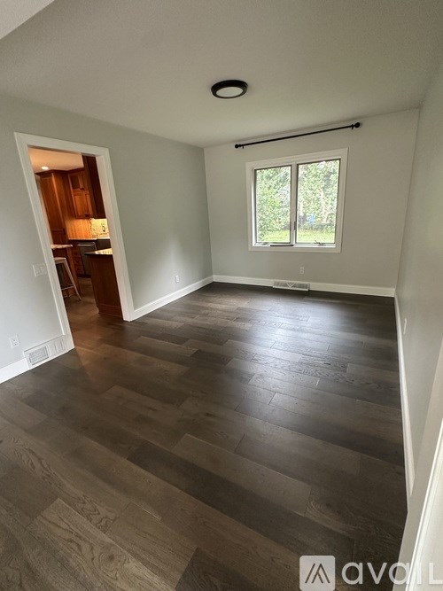 A room with wooden flooring and a window.