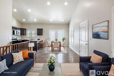 A living room with a blue couch and a coffee table in the middle.