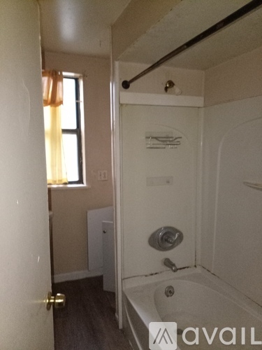 A bathroom with a tub and a window.