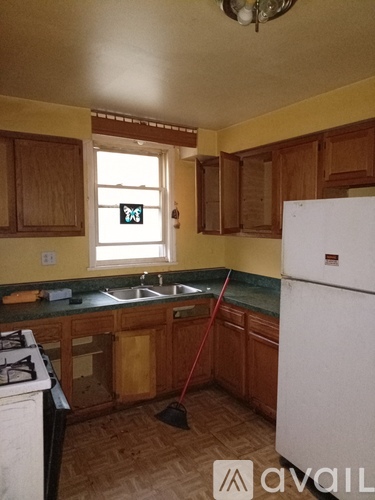 A kitchen with wooden cabinets and a white fridge.