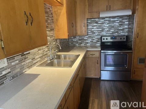 A kitchen with wooden cabinets and a stainless steel oven.